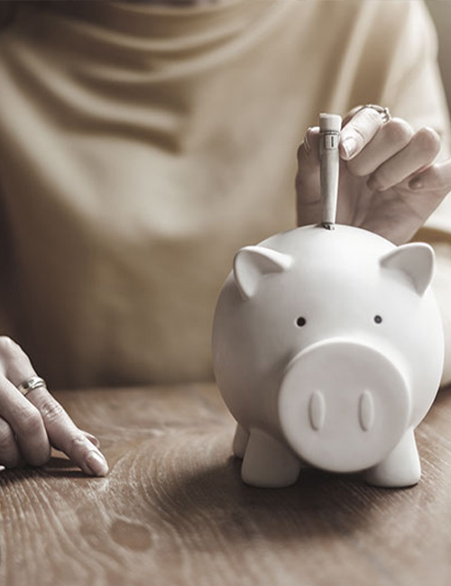 putting money away into a piggy bank